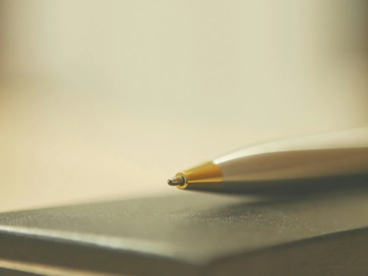 an inking pen resting on top of a piece of paper