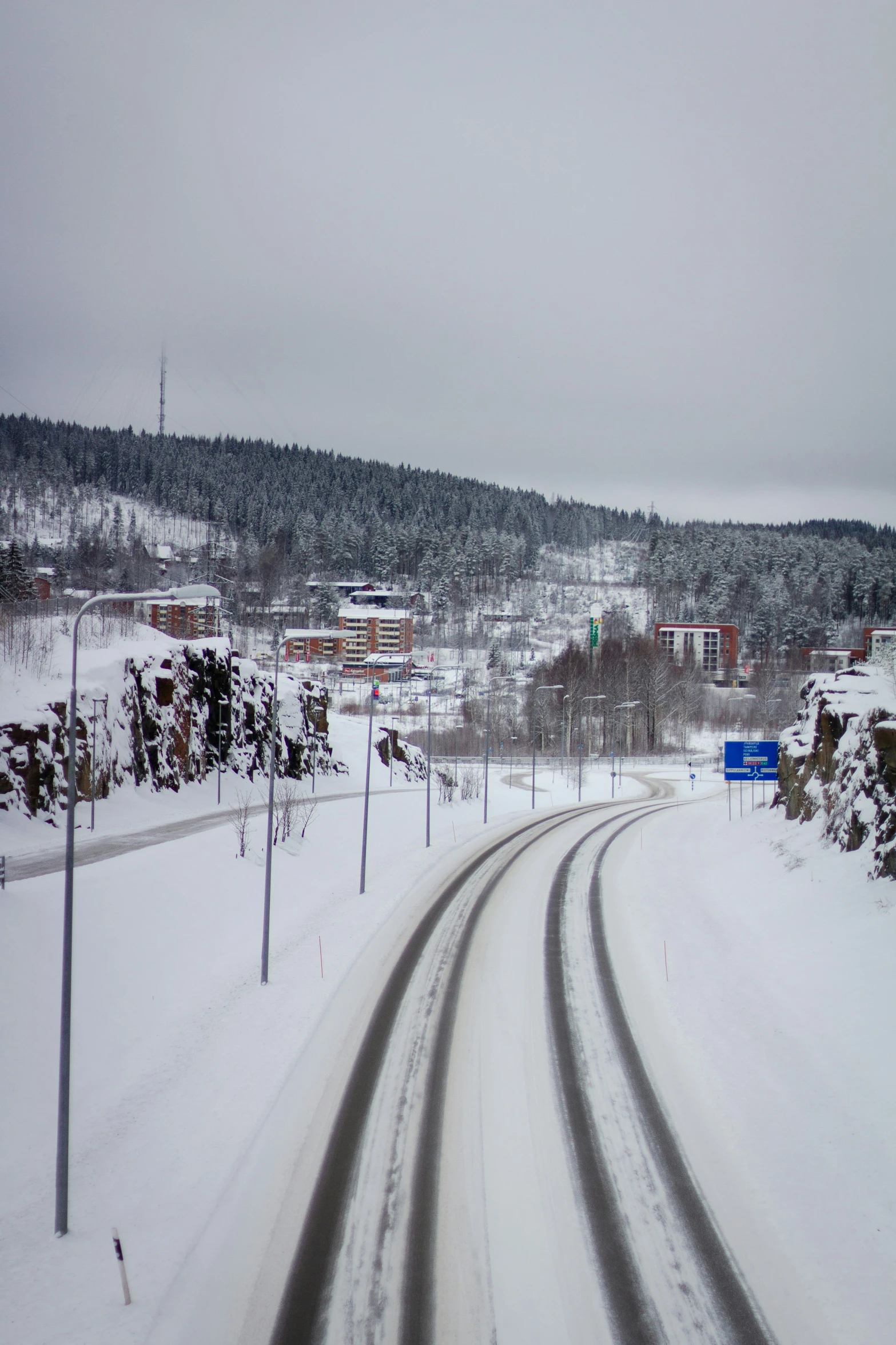 a snow covered road leads to a village