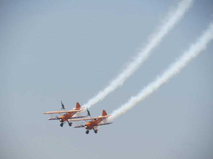 two planes flying in formation and smoke trail trailing