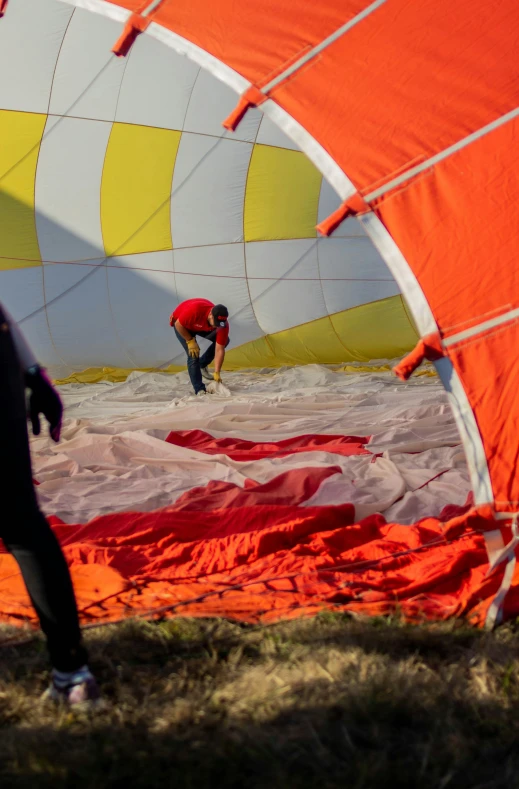 man fixing a parachute attached to a large kite