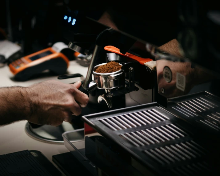 a person pouring coffee in front of a coffee maker