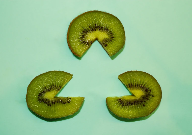 three kiwi slices are arranged in the shape of an arrow