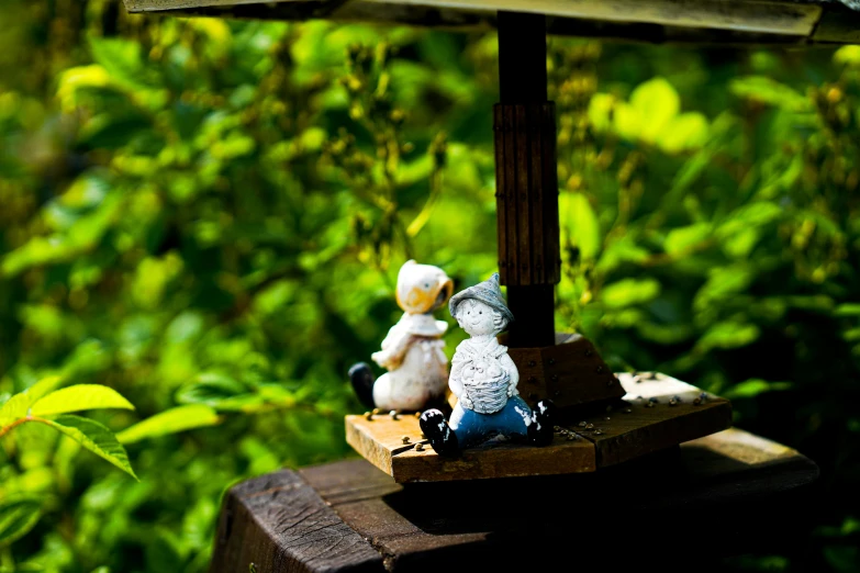 a bird feeder with two little birds sitting on top