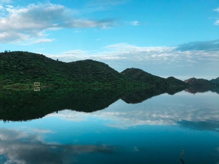 a beautiful scene of a small island with several hills reflected in it