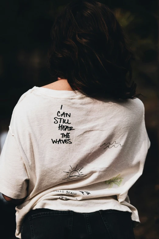 woman with white t - shirt with writing in the back