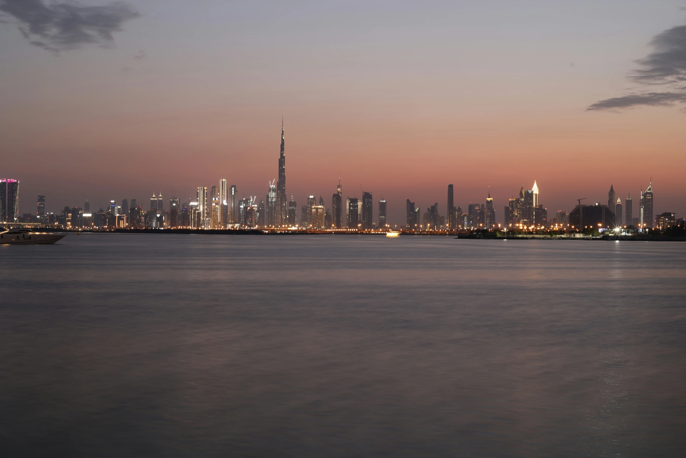 the city lights shine brightly over a wide body of water