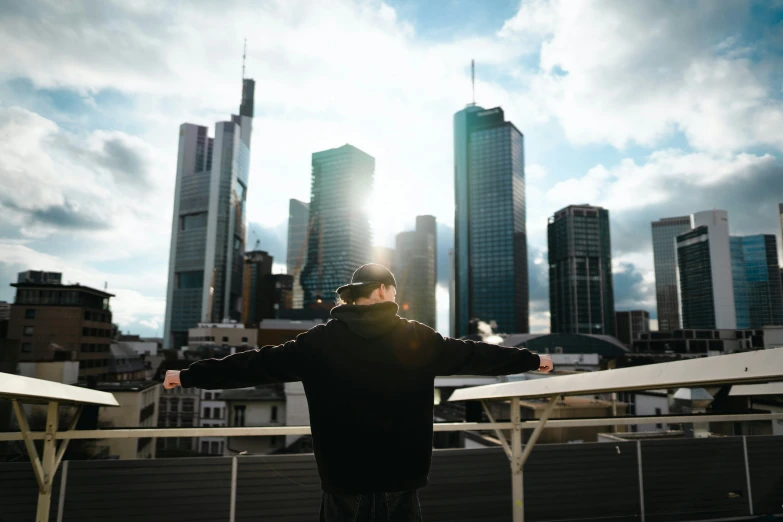 a man stands on a ledge and watches the city