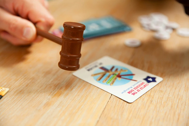 a hand with a wooden stick and some sort of stamp