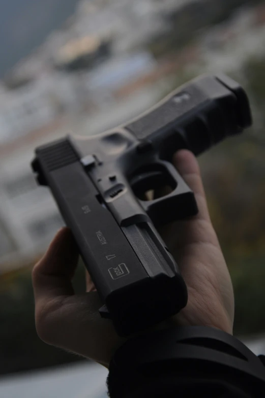 a person holds a gun that is pointed towards the camera