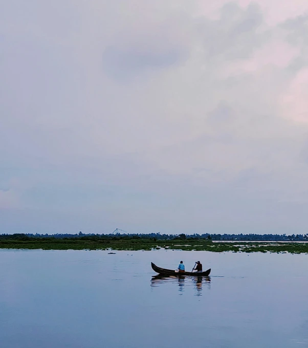 the man is sitting in his boat in the water