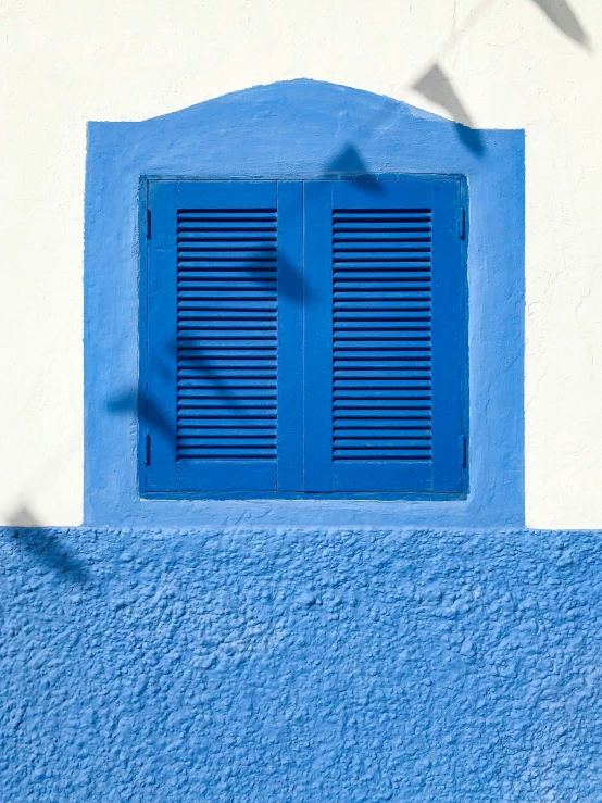 a window and shutters that appear to be blue