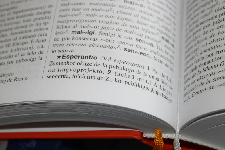 an open book with spanish text and an orange ribbon