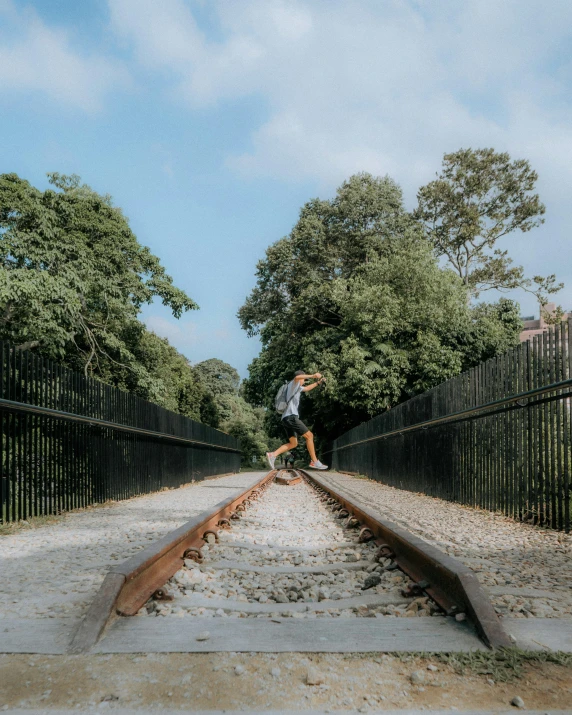 person riding a skateboard down railroad tracks