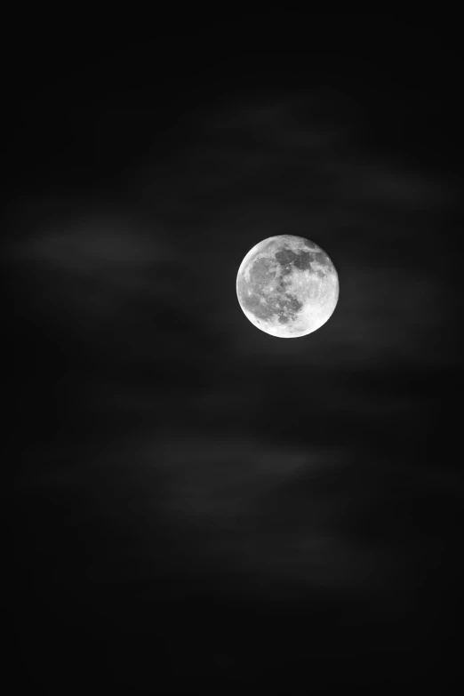 a full moon is in the black sky