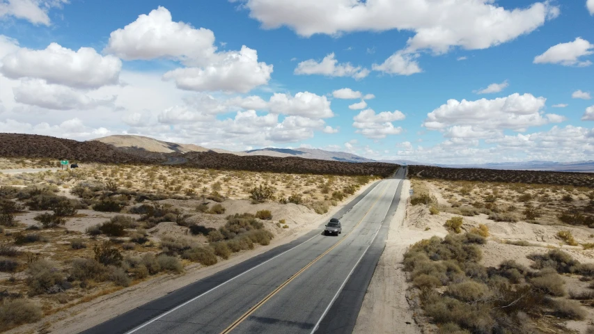 a vehicle driving through the desert on the highway