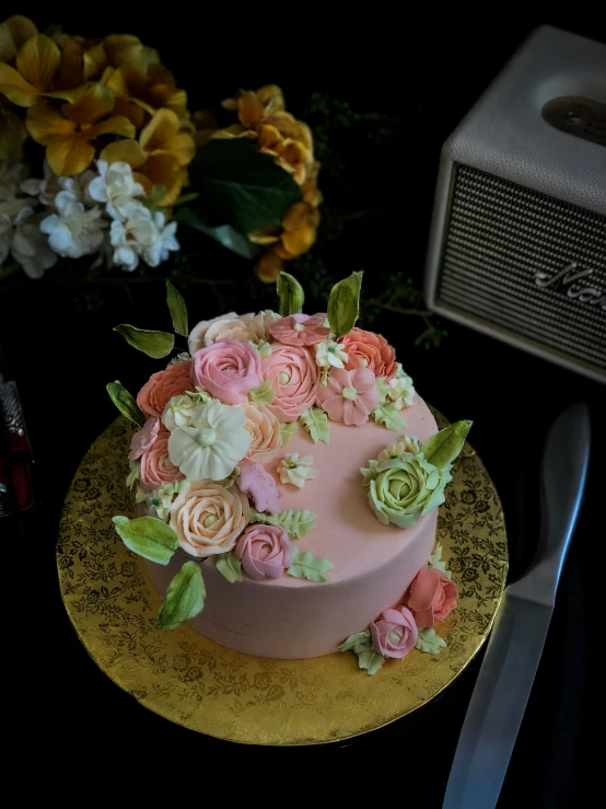 a pink cake with yellow and white flowers on top