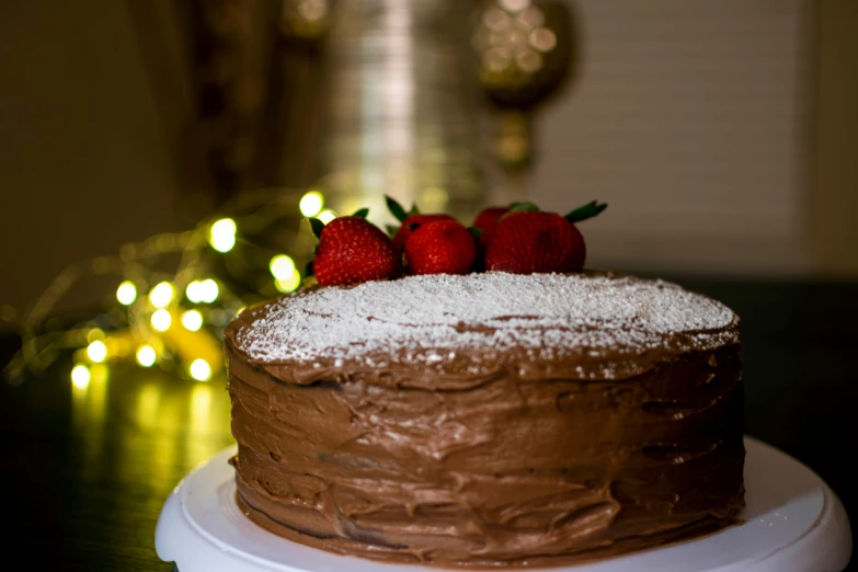 a round chocolate cake with strawberries on top