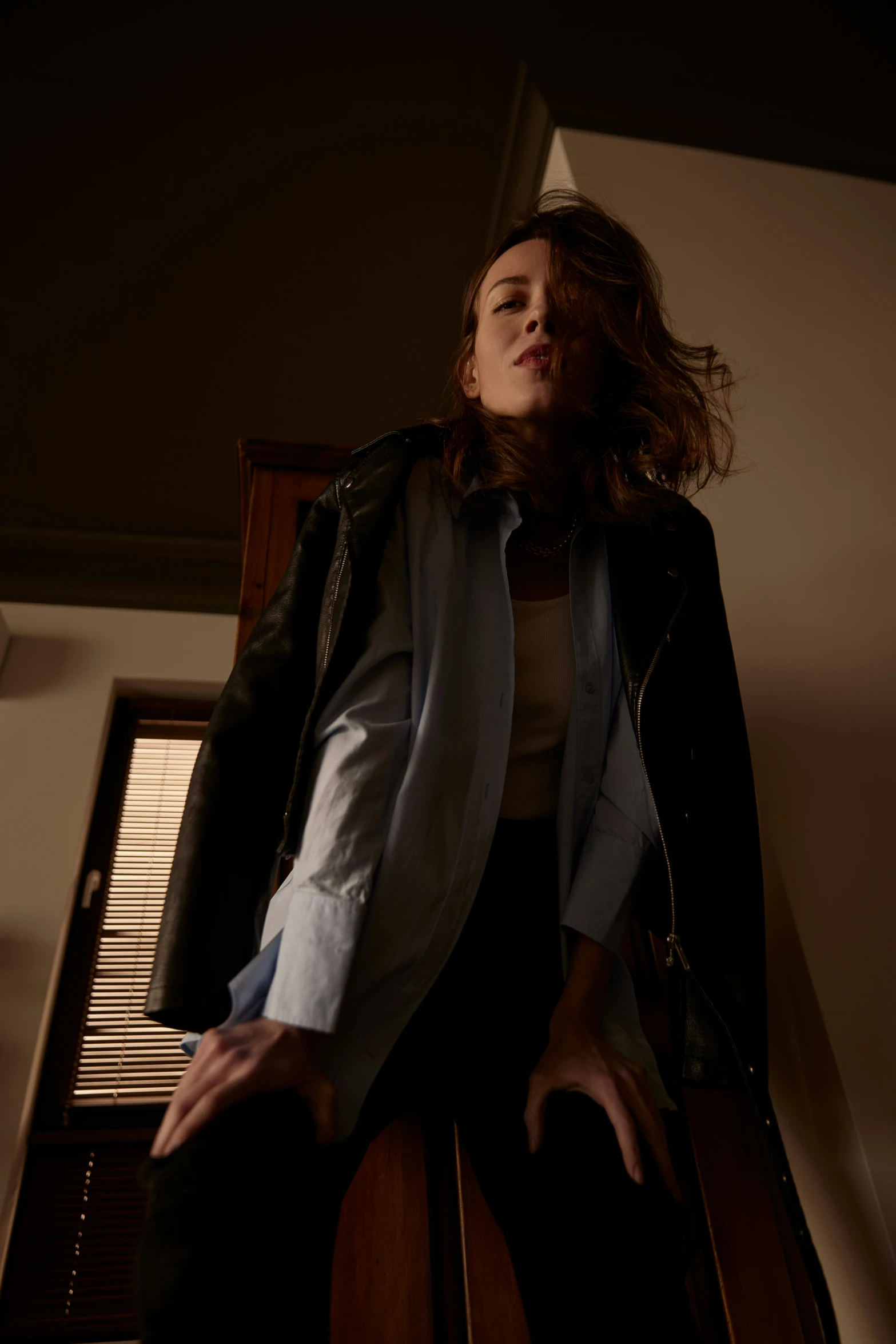 a girl sitting on a window sill with her hands resting on the windowsill