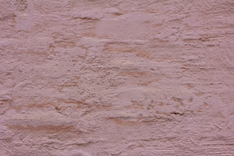 an orange fire hydrant in front of some dirty and white walls