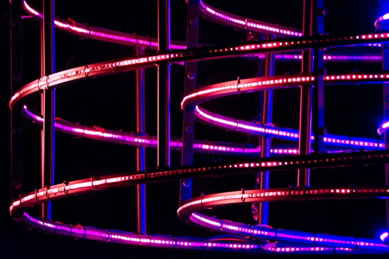 a neon sculpture is shown against a black background
