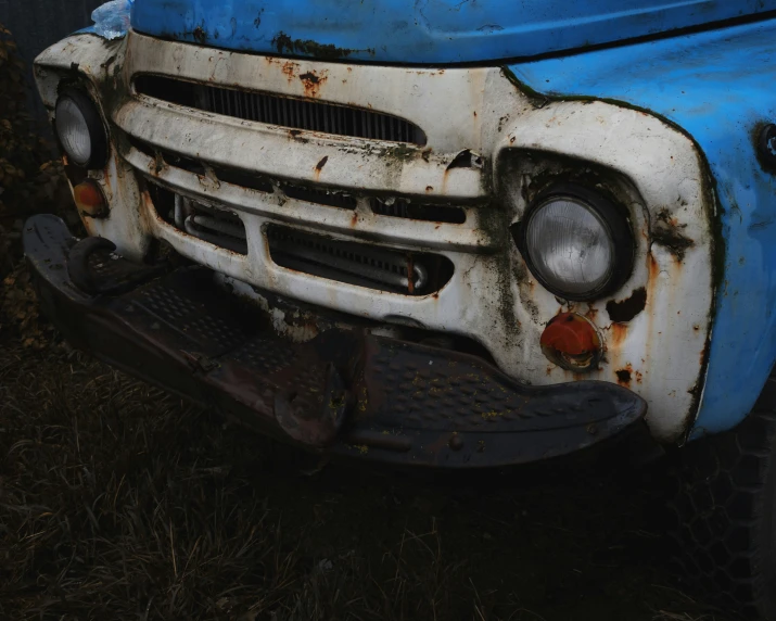 there is a blue and white pickup truck with some rust