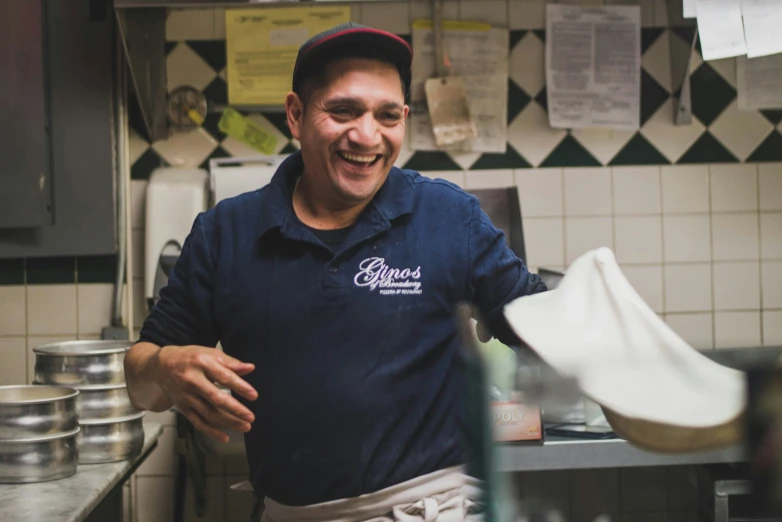 a man standing in a kitchen holding out his hand