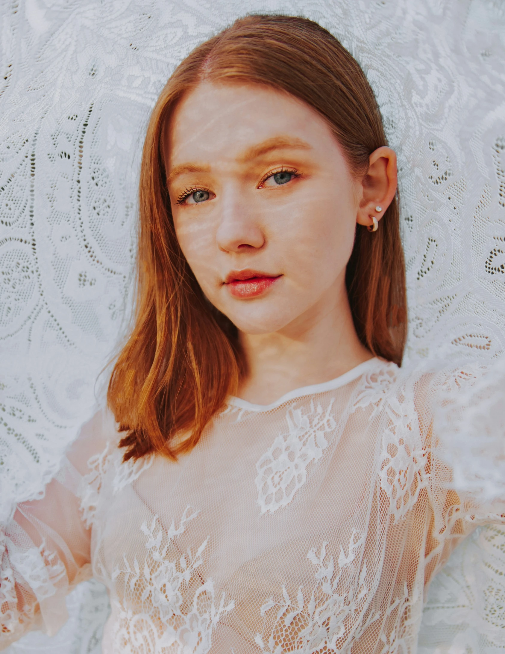 a girl with pale pink lips stands under an umbrella