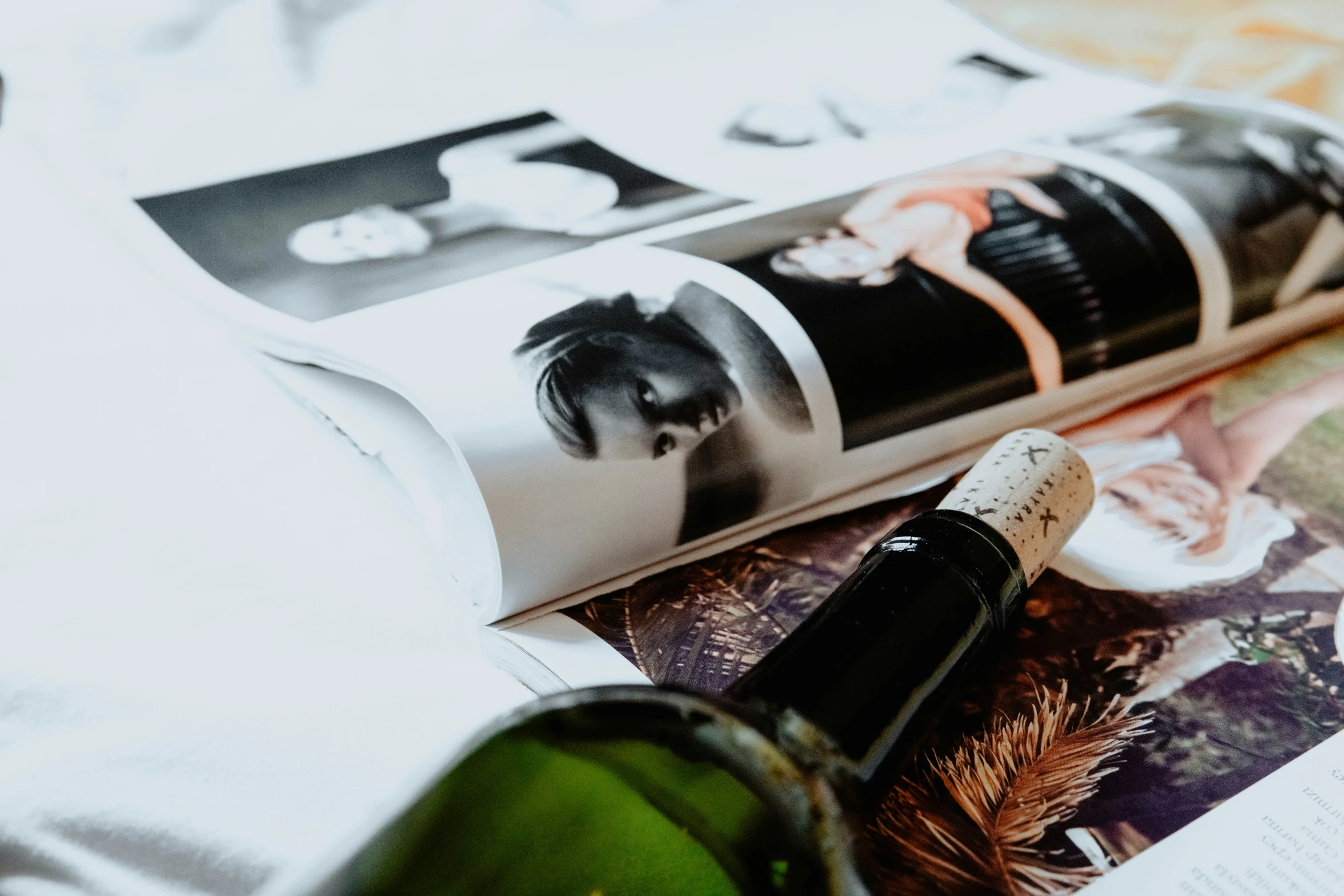 a bottle of wine and magazine are lying on the bed