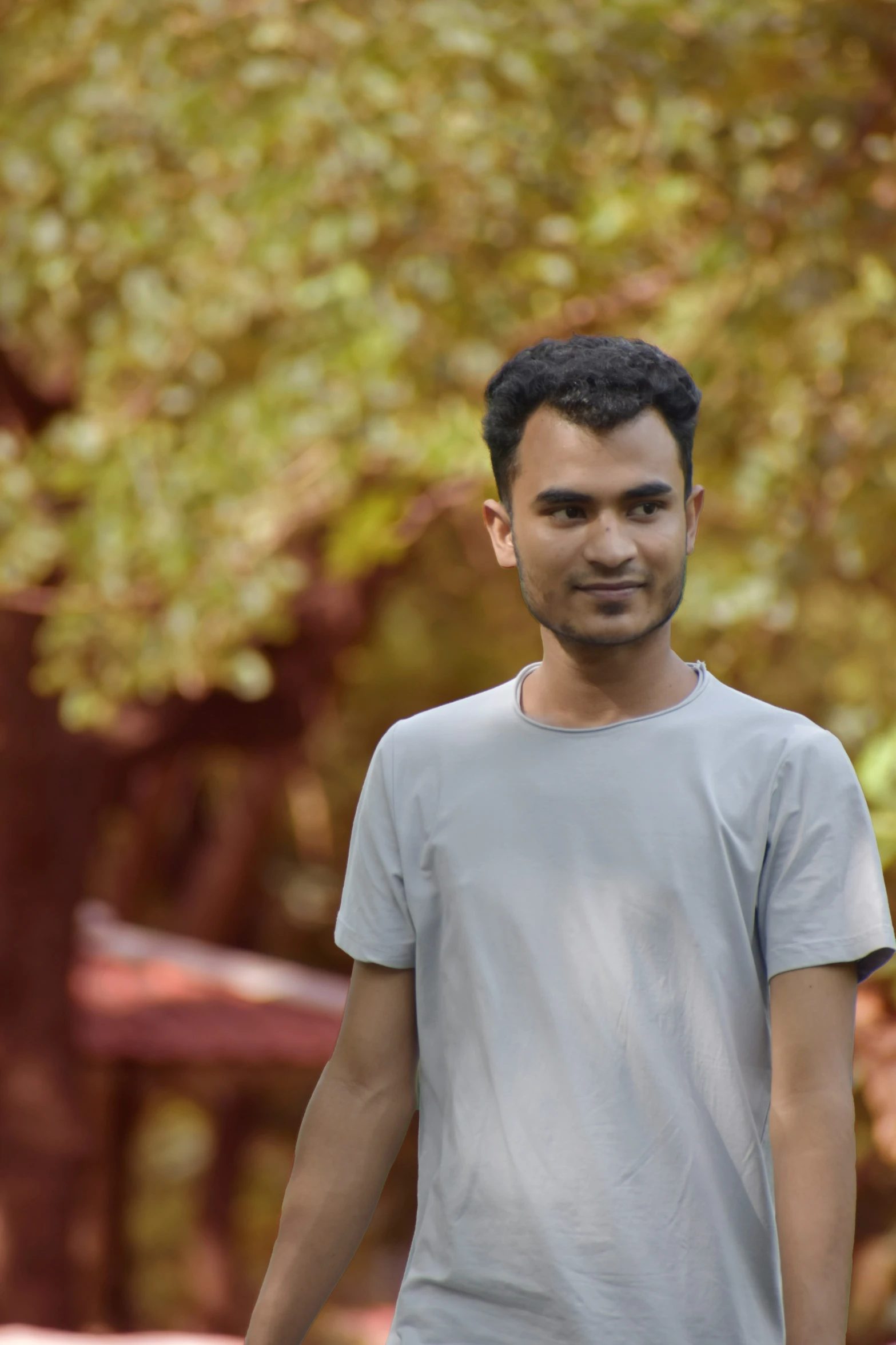 a man standing outside with his face slightly covered by his t - shirt