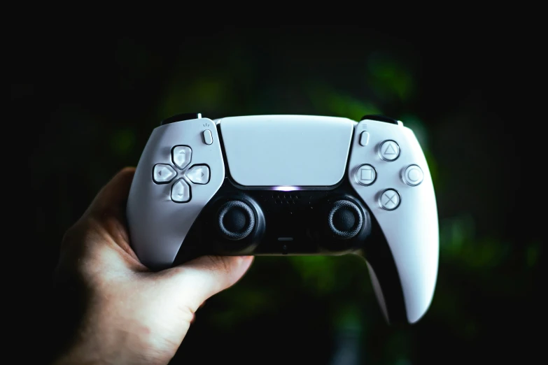 a white and black video game controller in hand