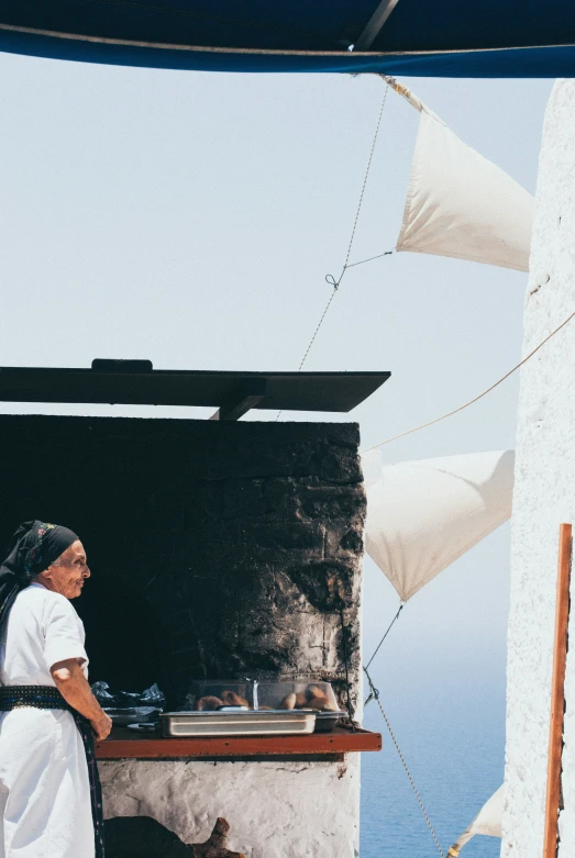 the women is cooking food at the open stove