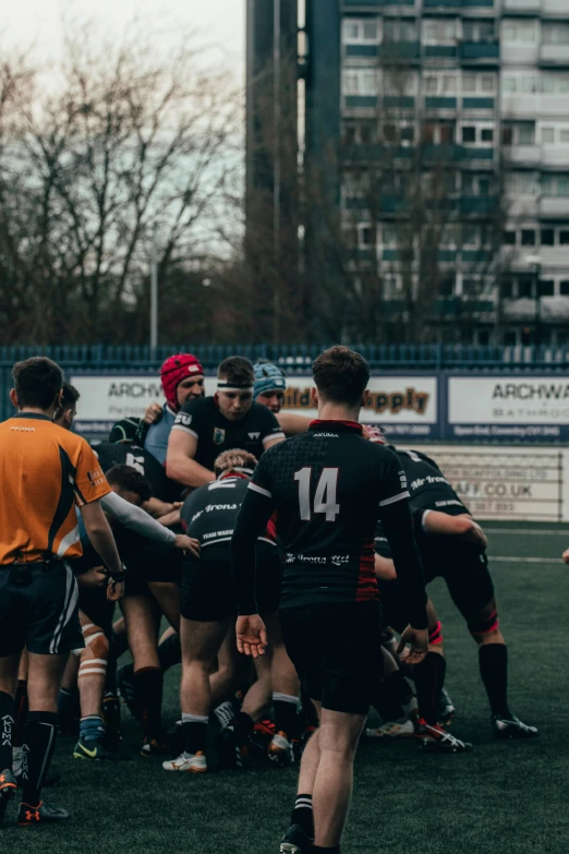 a team of rugby players huddle around in a scrumbable