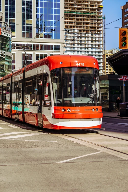 a red and white streetcar traveling on an urban street