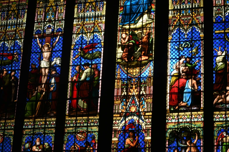 a large multicolored stained glass window on the side of a building