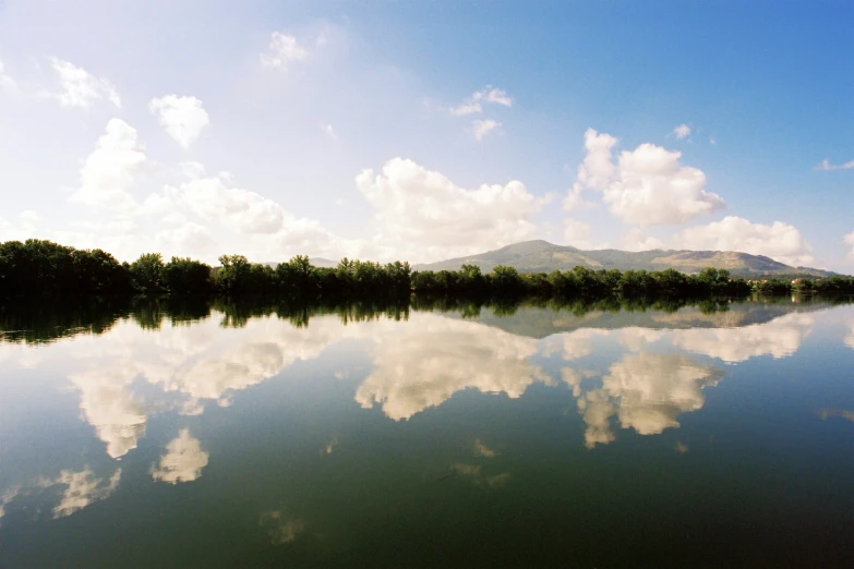 the large body of water is reflecting the mountain