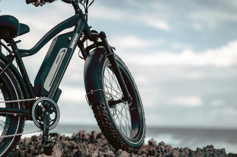 a single bicycle parked on top of a rocky beach