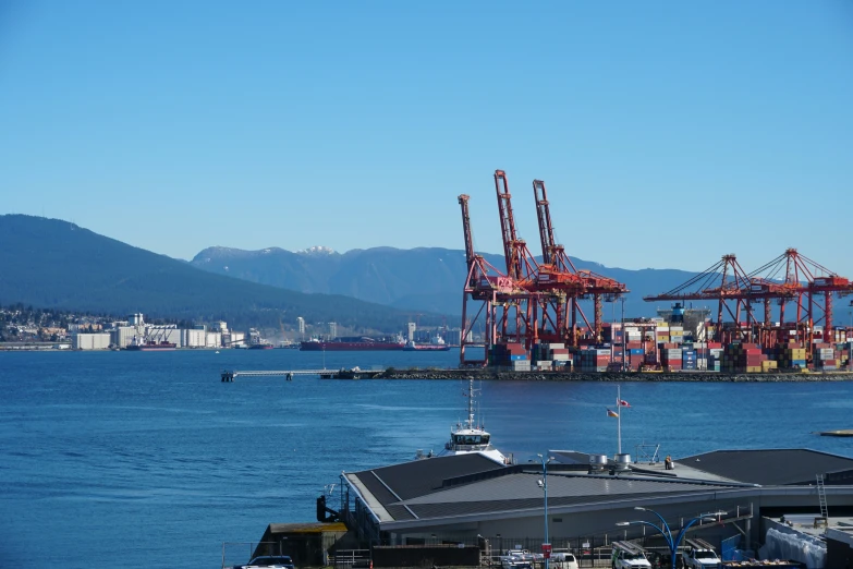 cranes are on the dock in front of the mountain