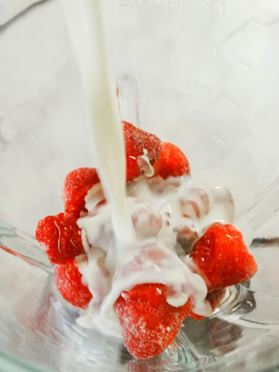 there is a strawberry mix being made with yogurt and strawberries