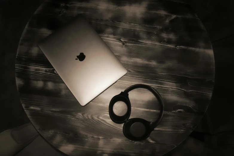 a laptop and headphones sit on a table