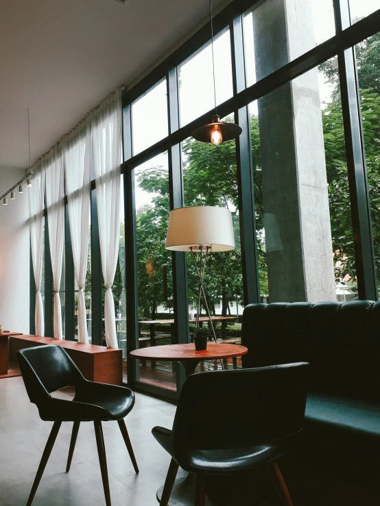 black chairs are placed in the lobby and lights shine on the floor