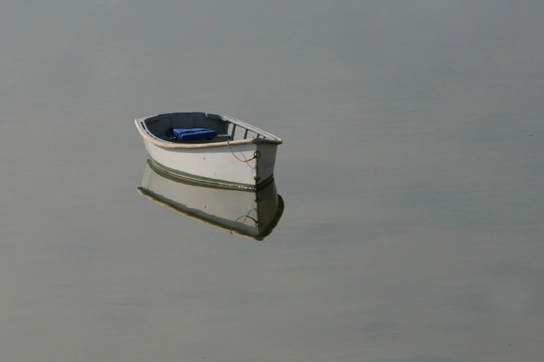 an old row boat sitting in the middle of the water