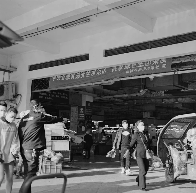 an old po of people walking around the market