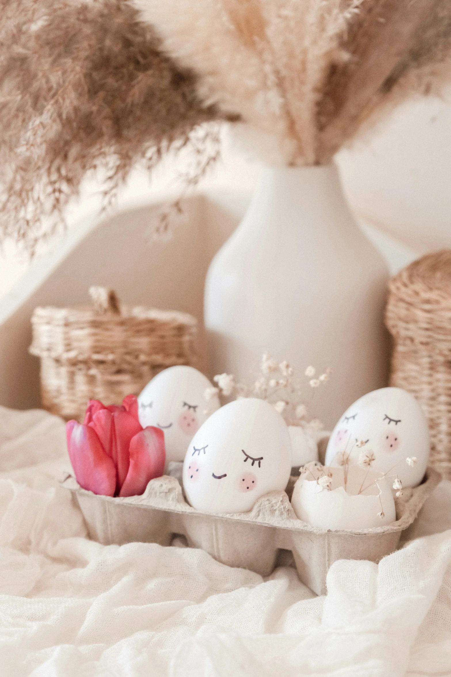 eggs in basket with flowers on the side, white vase behind