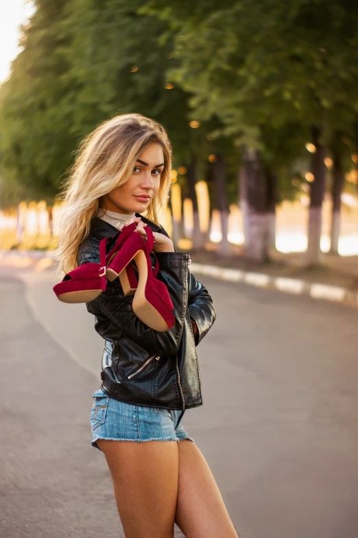 a beautiful woman with long legs wearing a black jacket and shorts