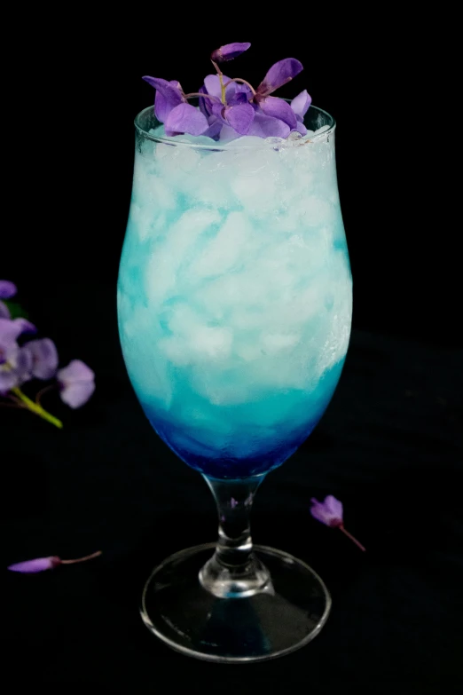 a glass filled with a liquid and flowers