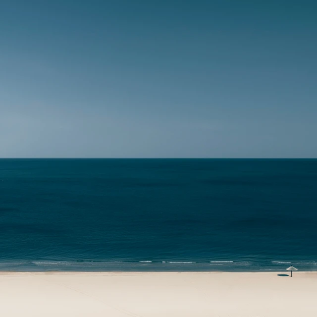 a man walking on the beach carrying his surfboard