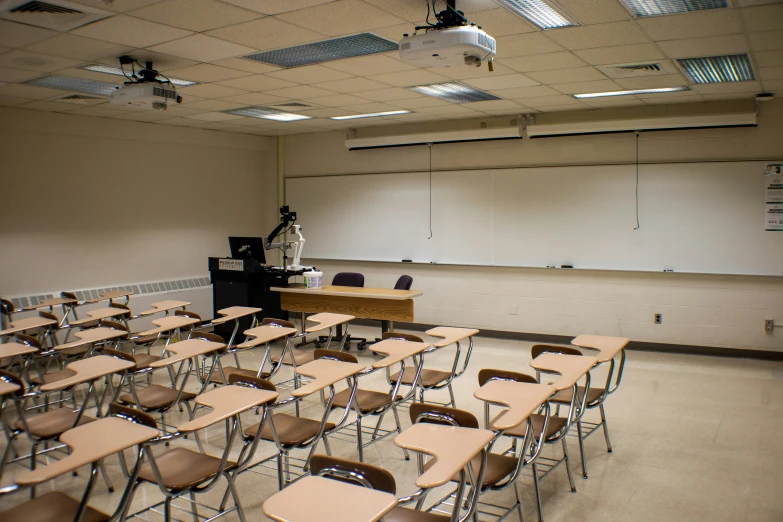 a classroom filled with lots of desks and a blackboard