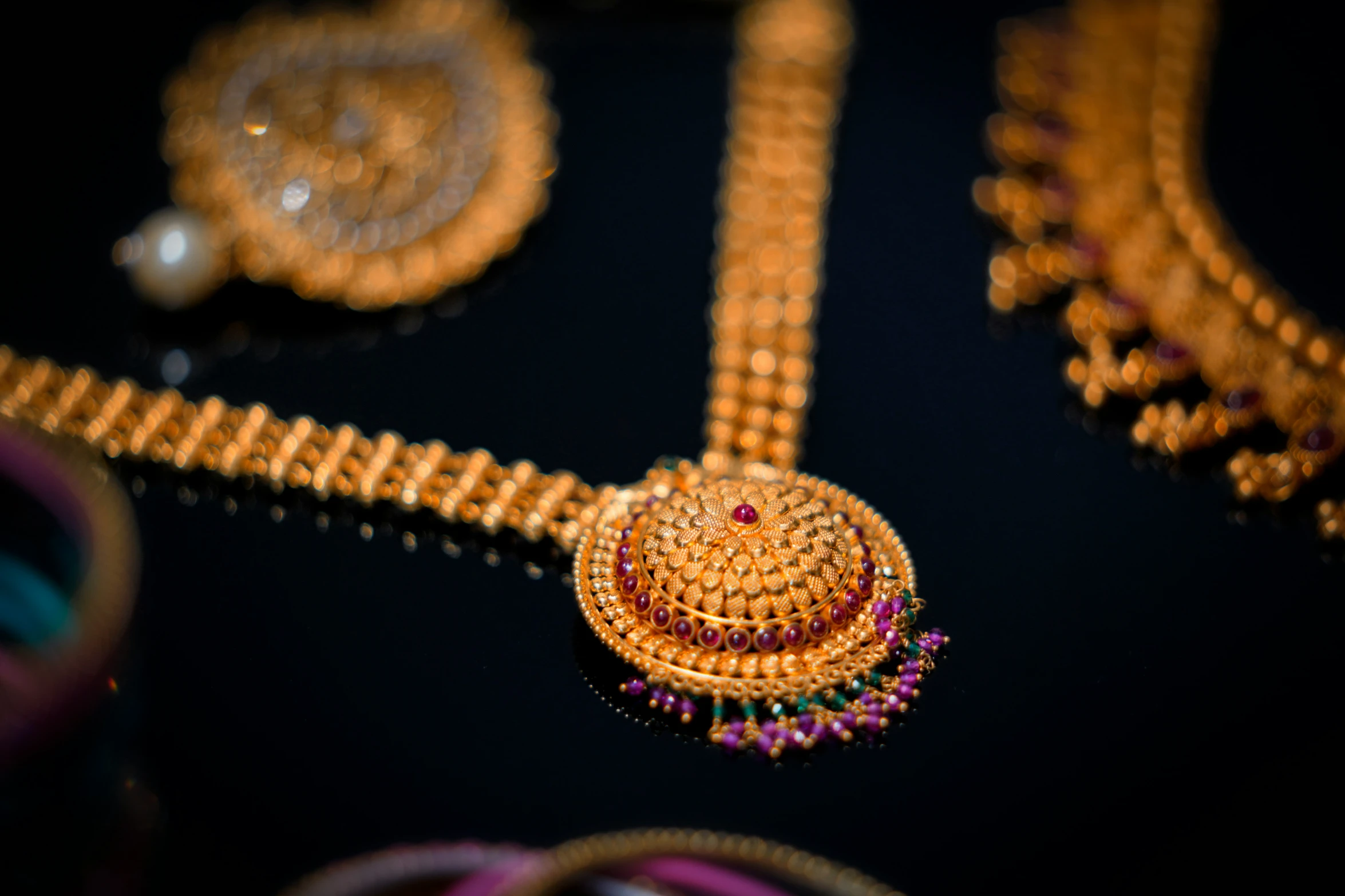 a gold and ruby necklace is shown on a black background