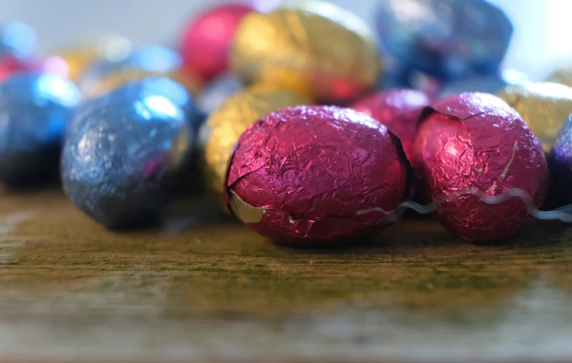 several colored chocolate candies arranged on a wooden table