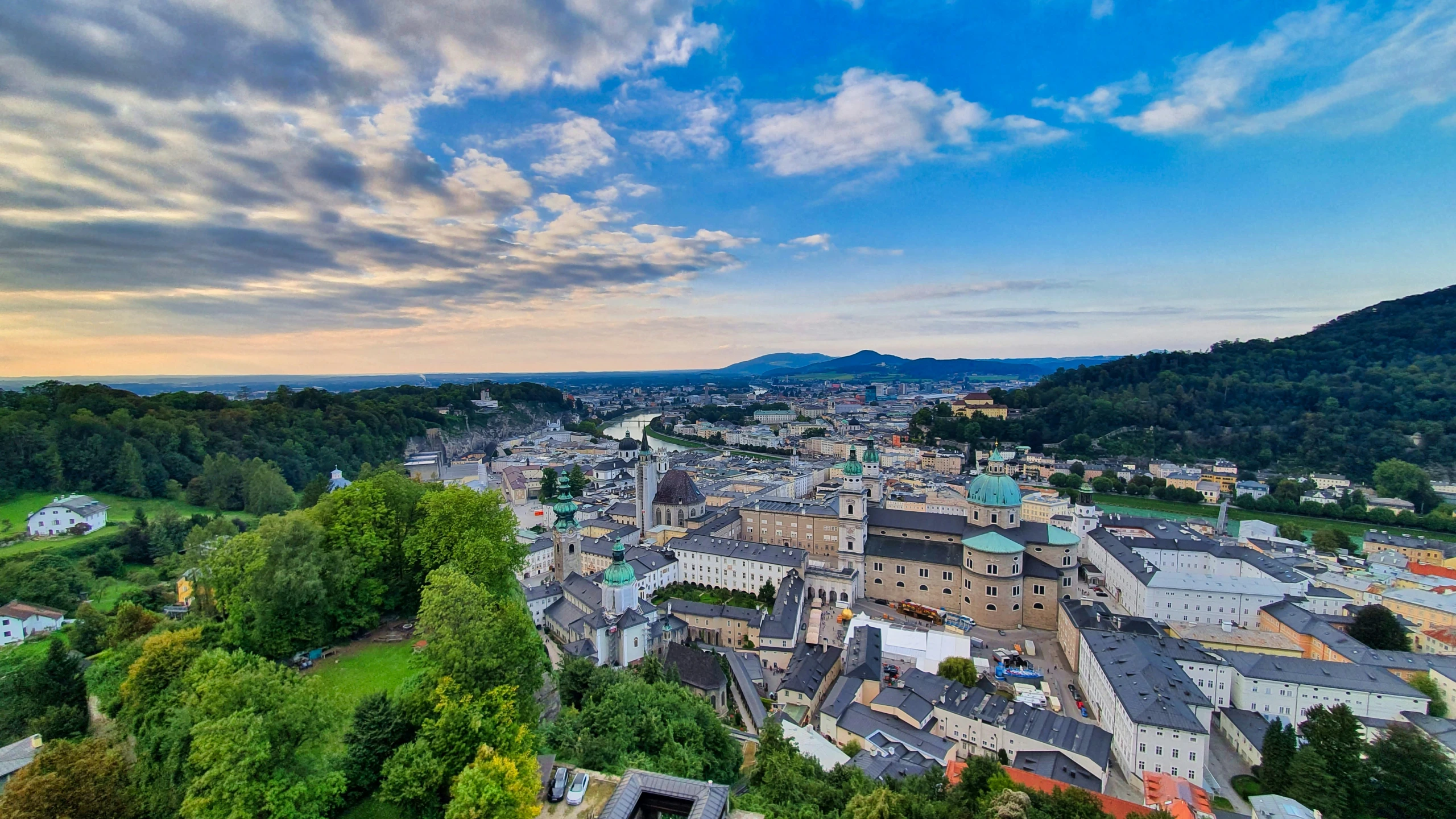 the city is surrounded by large hills in the background